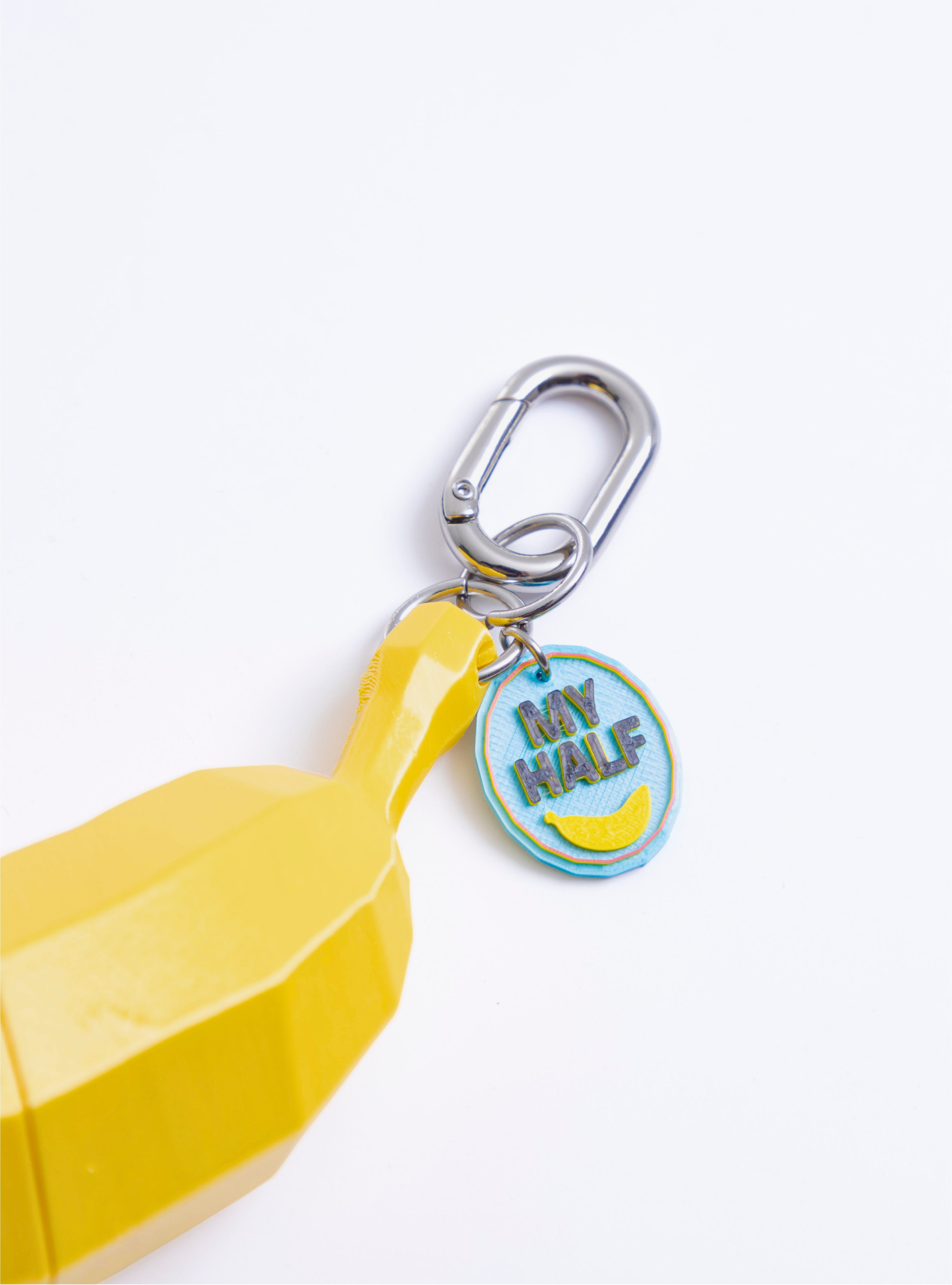 Detalle del Charm Banano Loft Me mostrando la argolla metálica y el gancho