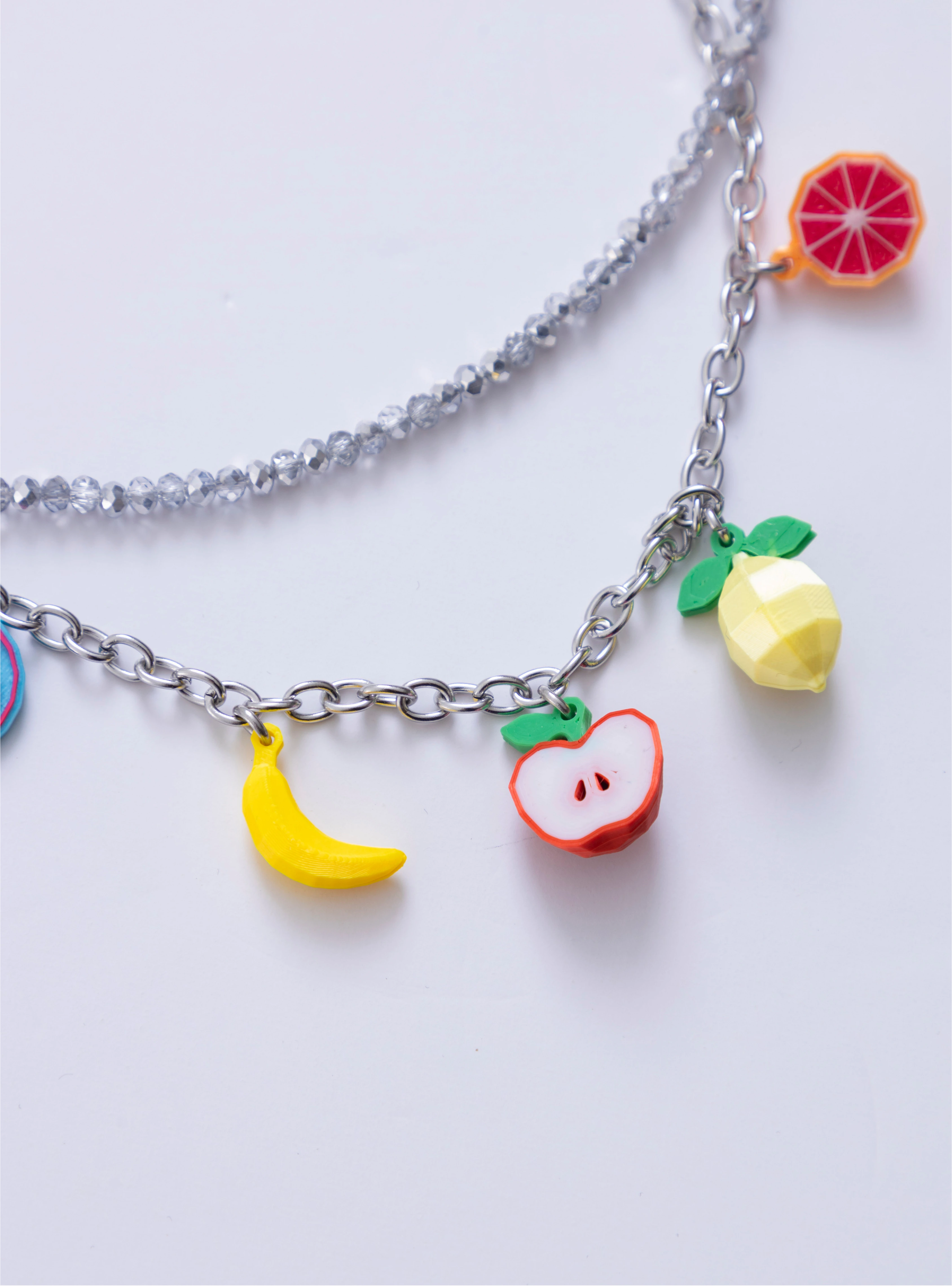 Detalle del Collar Juicy Punch Loft Me con charms de banano amarillo y manzana 3D.